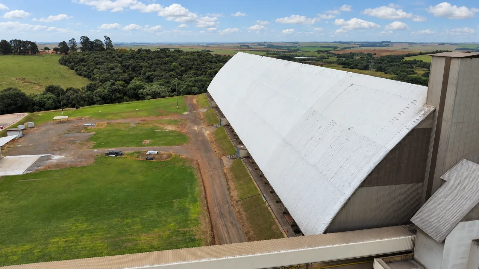 Paisagem industrial sob céu azul — impermeabilização de cobertura
